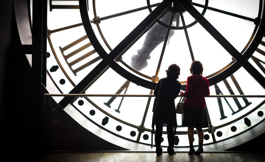 two women looking at huge clock